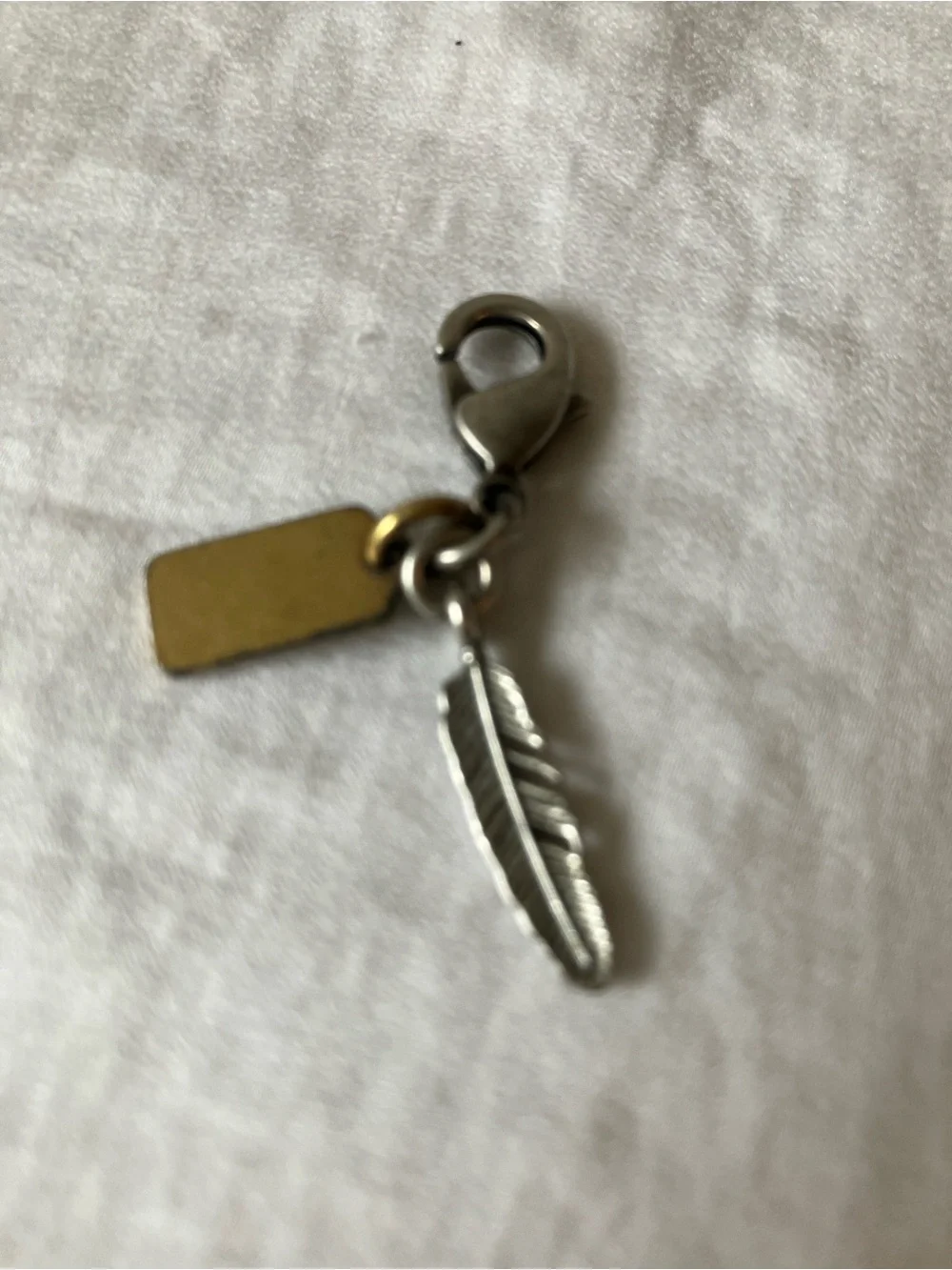 Coach: Silver Tone & Gold Tone Feather Charm Keyring